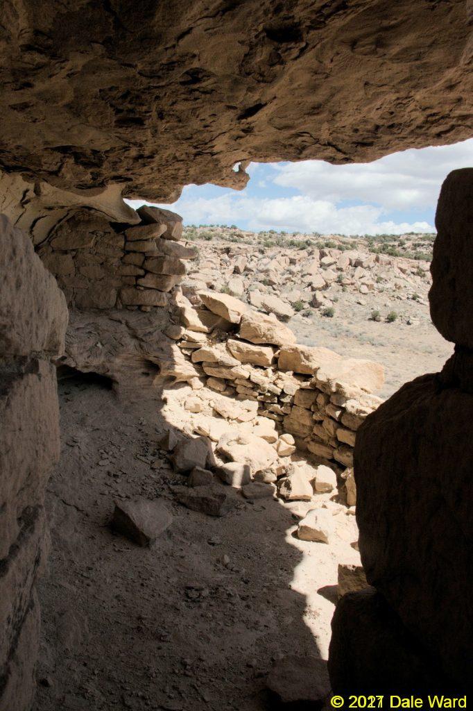 Looking through the doorway and wall of a cliff ruin
